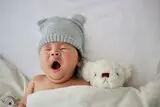 Baby mit Mütze gähnt