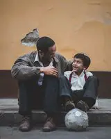 Mann sitzt neben einem Jungen 