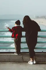Frau mit Kind schaut auf das Meer 